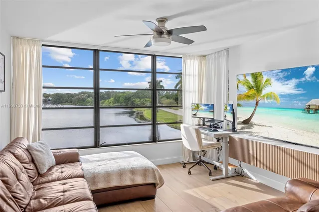a living room with furniture a floor to ceiling window and a flat screen tv