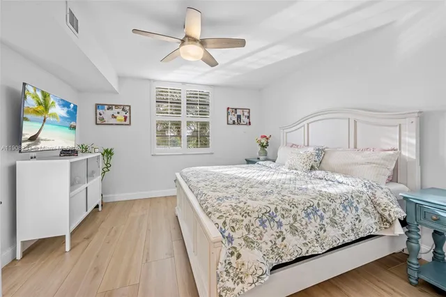 a bedroom with a large bed a chandelier and a window