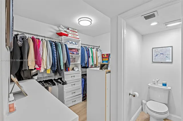 a view of walk in closet with clothes and shoes
