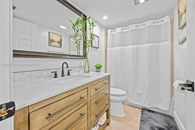 a bathroom with a double vanity sink toilet and shower