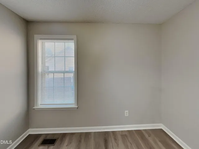 a view of a small space with wooden floor and a window