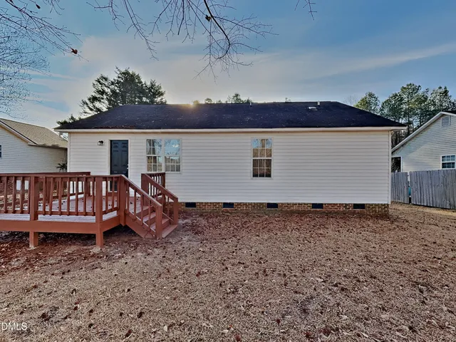 a view of a house with wooden deck and a yard