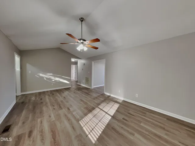 a view of a room with wooden floor fan and a ceiling fan