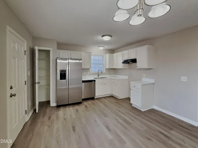 a kitchen with stainless steel appliances a refrigerator sink and cabinets