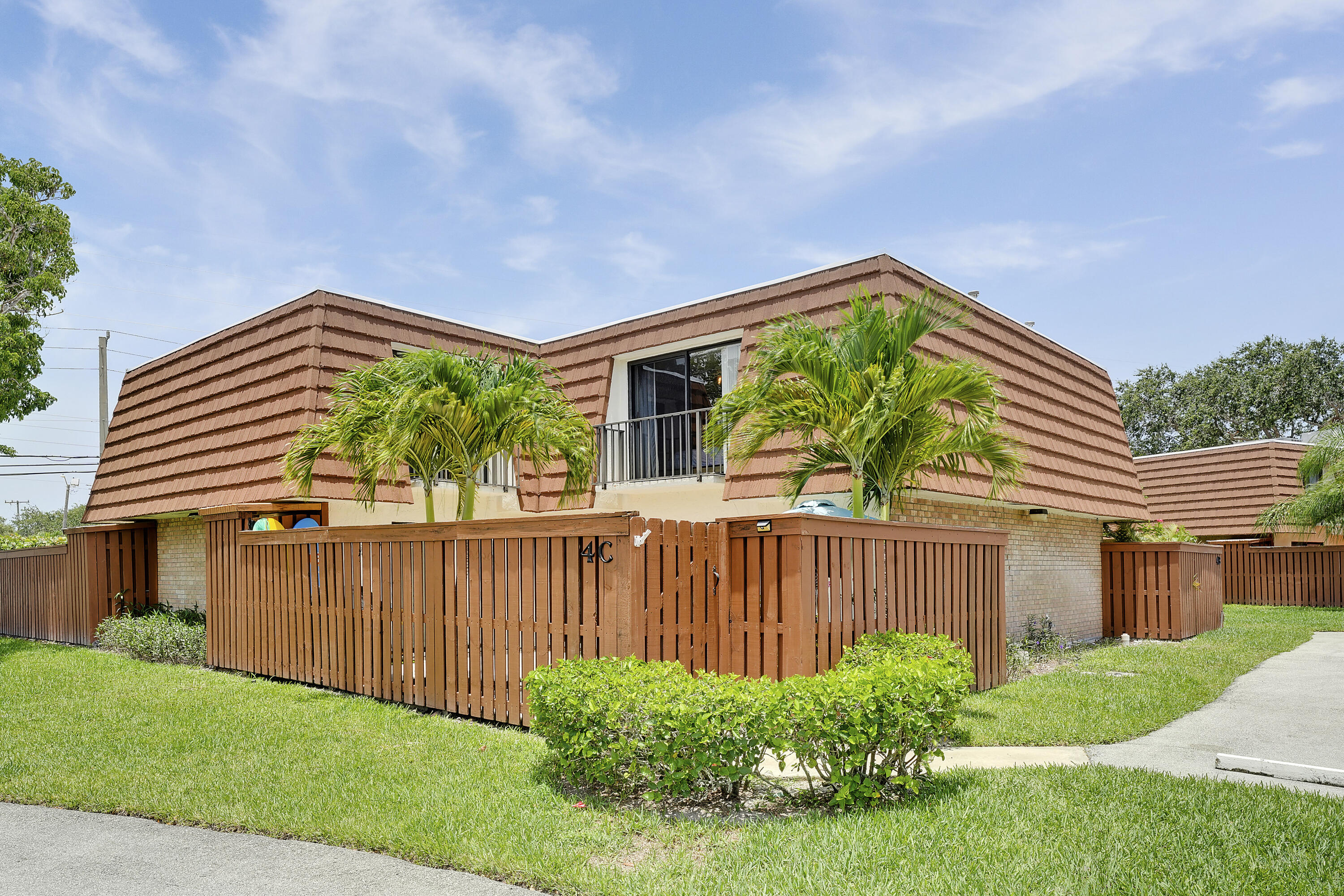 3900 County Line Road, Unit 4C Tequesta, FL 33469 - Photo 23 of 41 a view of a house with a yard plants and wooden fence
