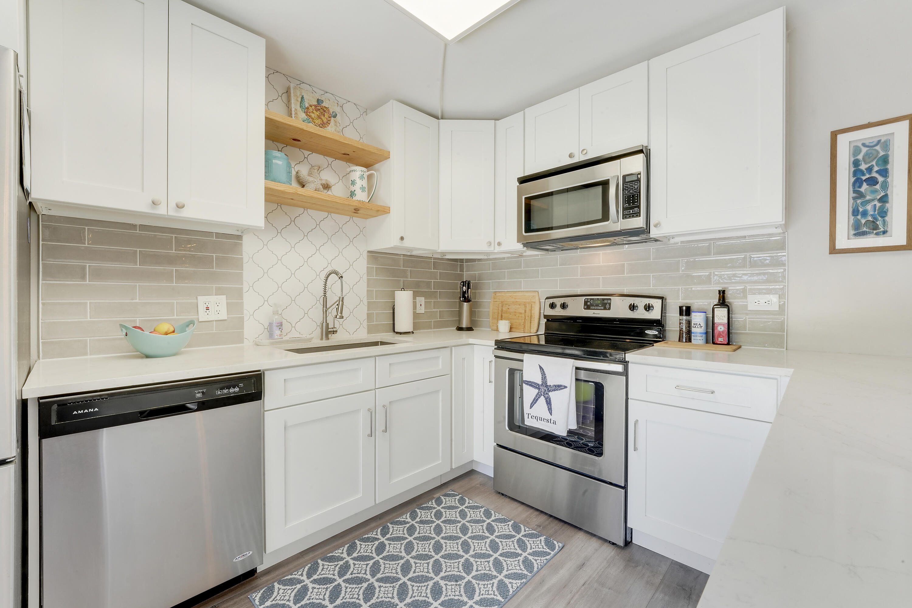 3900 County Line Road, Unit 4C Tequesta, FL 33469 - Photo 8 of 41 a kitchen with stainless steel appliances granite countertop white cabinets a sink and dishwasher