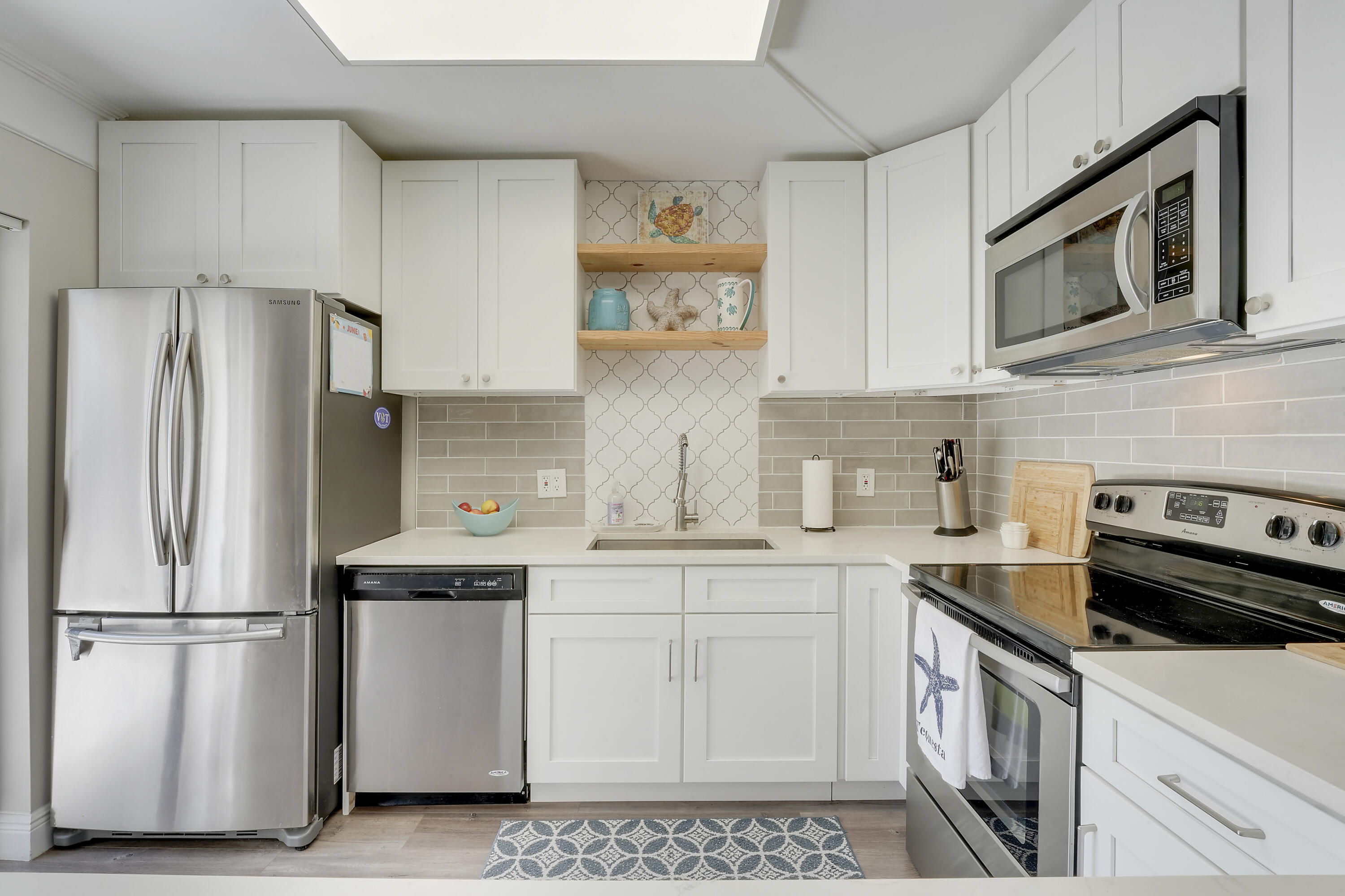 3900 County Line Road, Unit 4C Tequesta, FL 33469 - Photo 9 of 41 a kitchen with stainless steel appliances a refrigerator sink and microwave