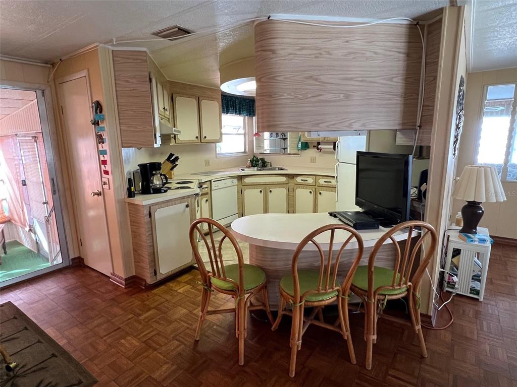 41 Royal Palm Circle Largo, FL 33778 - Photo 11 of 27 a kitchen with stainless steel appliances kitchen island granite countertop a table chairs and a refrigerator