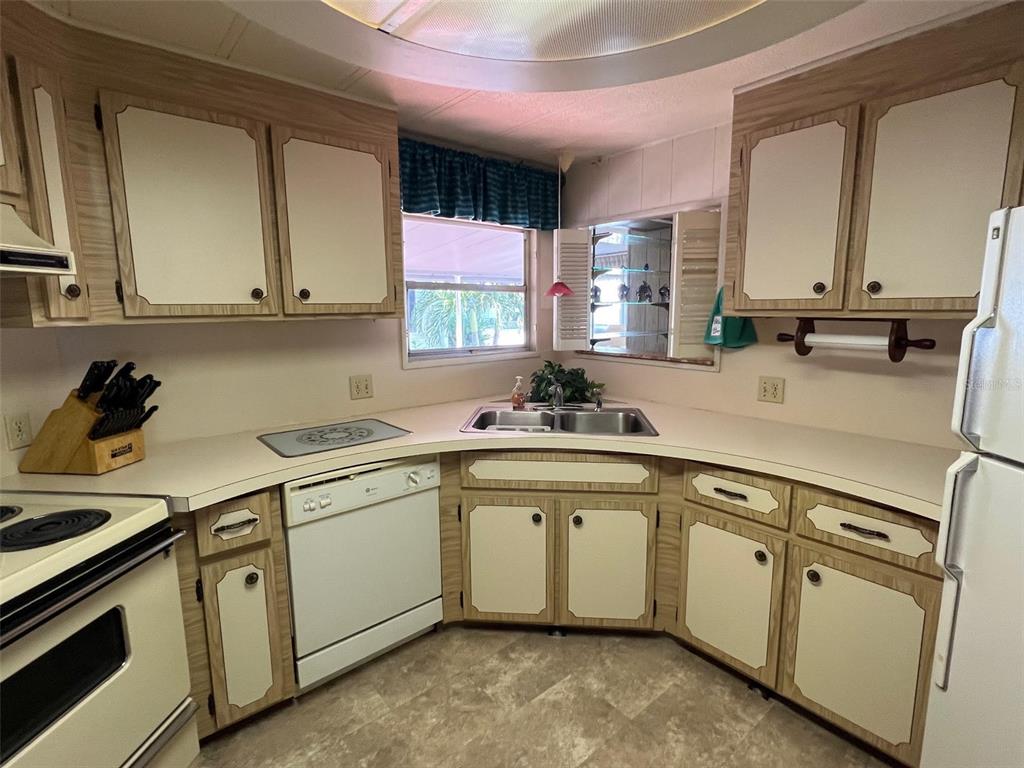 41 Royal Palm Circle Largo, FL 33778 - Photo 13 of 27 a kitchen with white cabinets and white appliances