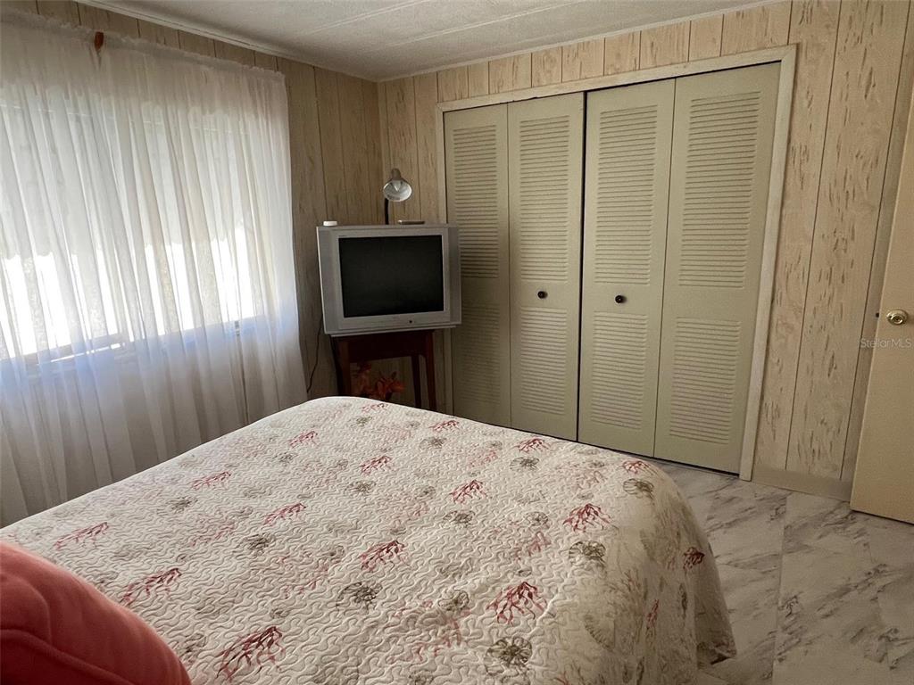 41 Royal Palm Circle Largo, FL 33778 - Photo 16 of 27 a bedroom with a bed and a flat tv screen in it