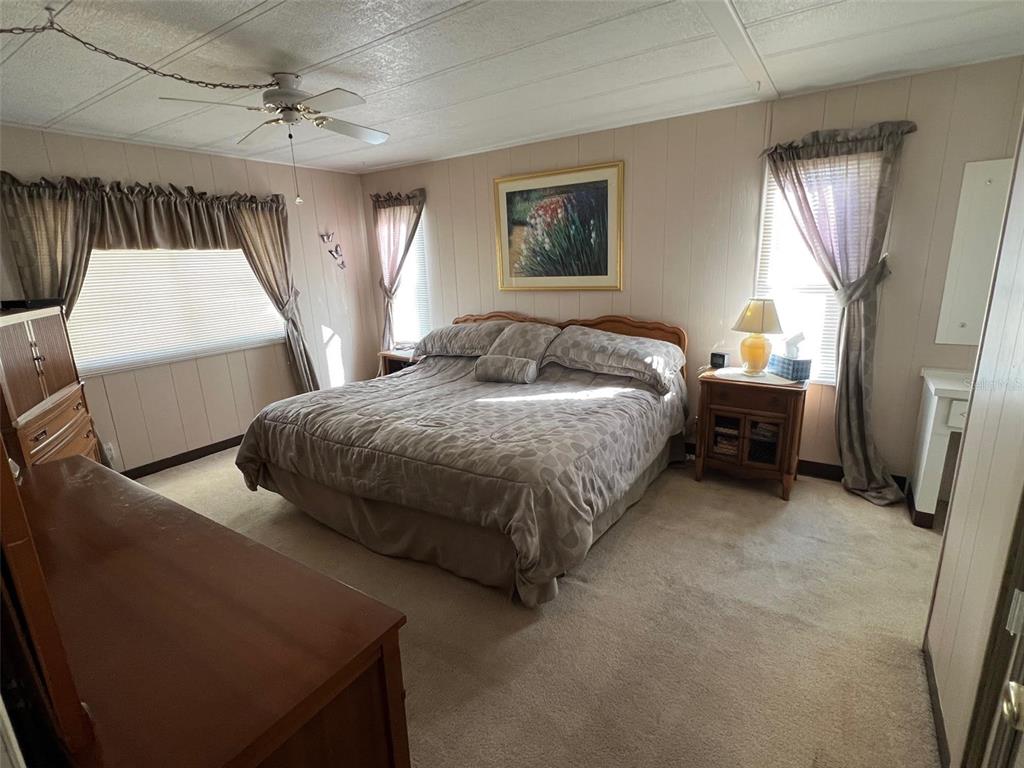 41 Royal Palm Circle Largo, FL 33778 - Photo 21 of 27 a spacious bedroom with a bed and a chandelier