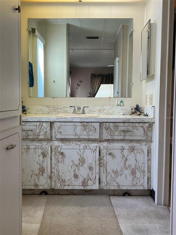41 Royal Palm Circle Largo, FL 33778 - Photo 25 of 27 a bathroom with a sink and a mirror