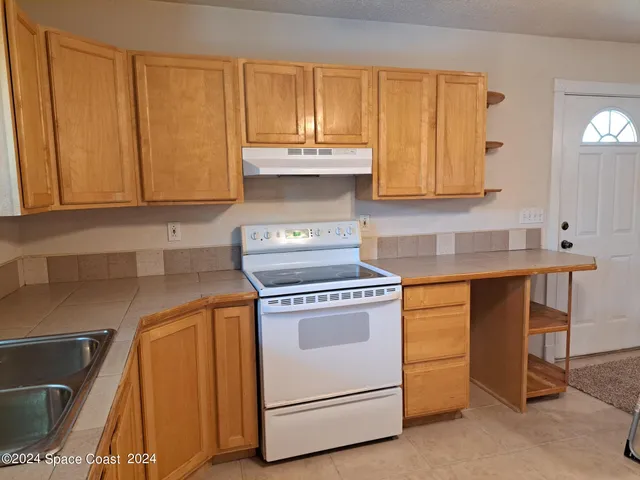 a kitchen with granite countertop cabinets stainless steel appliances and a counter space