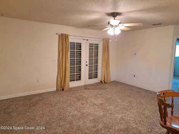 a view of a livingroom with a ceiling fan and window