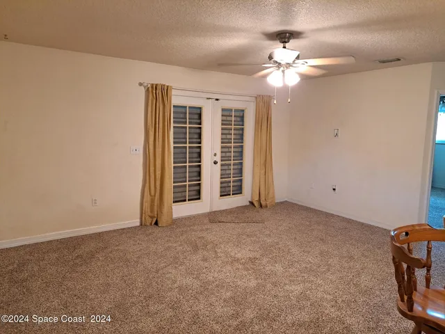 a view of a livingroom with a ceiling fan and window
