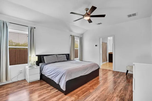 a bedroom with a large bed a chandelier and a window