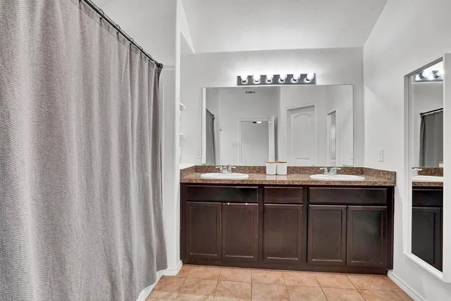 a bathroom with a double vanity sink and a mirror