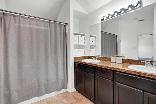 a bathroom with a double vanity sink and a mirror