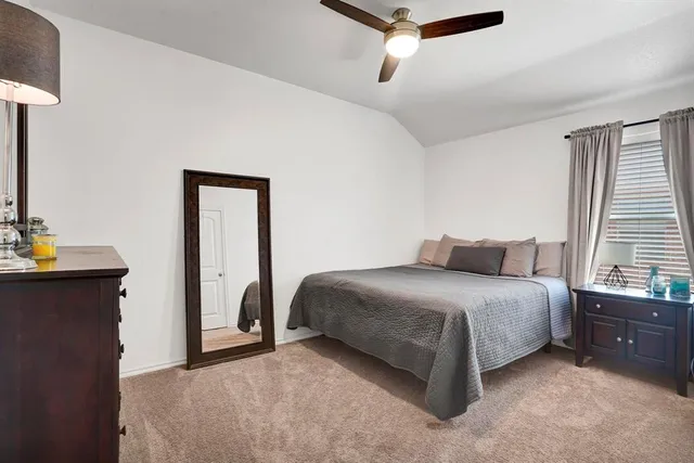 a spacious bedroom with a bed and a mirror