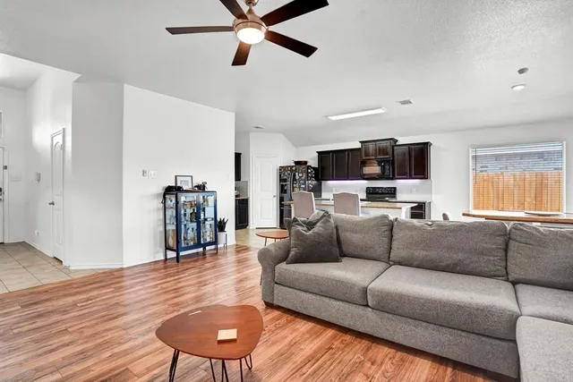 a living room with furniture and a wooden floor