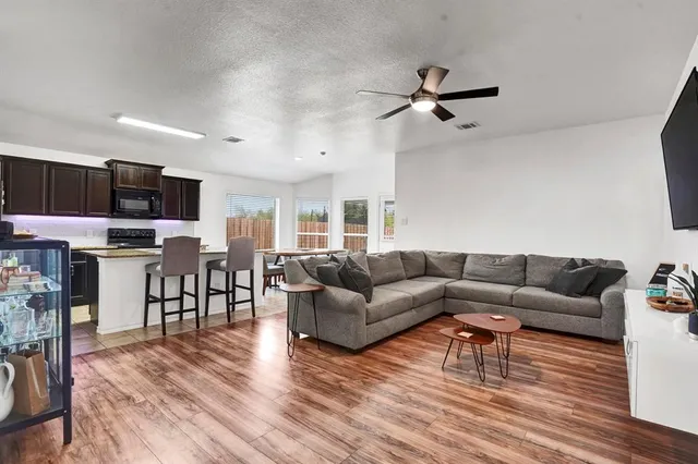 a living room with furniture and a wooden floor