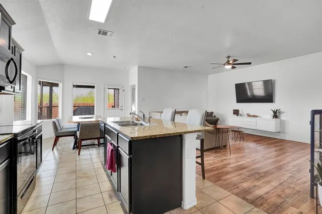 a living room with furniture a flat screen tv and a dining table