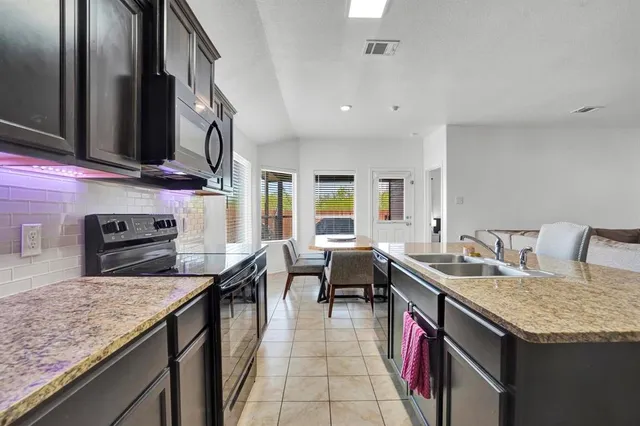 a kitchen with stainless steel appliances granite countertop a sink stove and oven