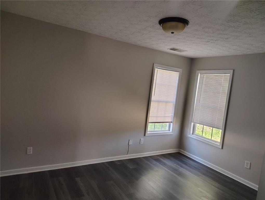 85 Hollow Court Covington, GA 30016 - Photo 2 of 9 an empty room with wooden floor and windows