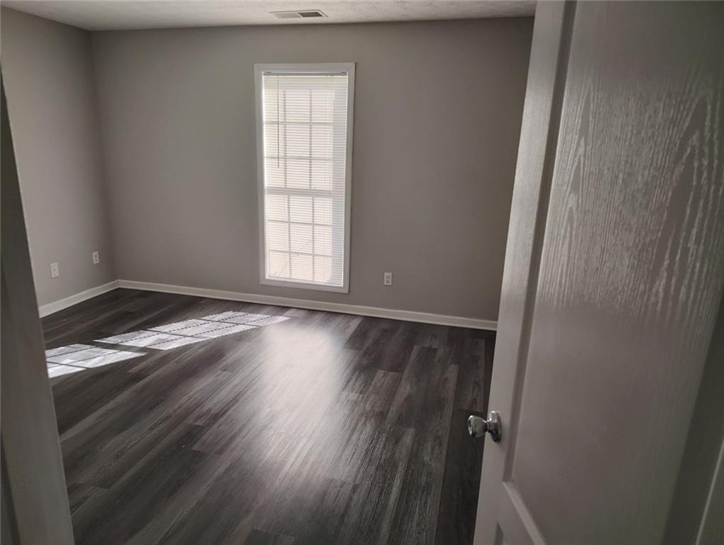 85 Hollow Court Covington, GA 30016 - Photo 8 of 9 an empty room with wooden floor and windows