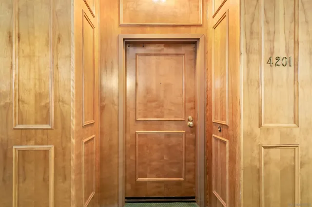 a spacious bedroom with a bed a table and painting on the wall