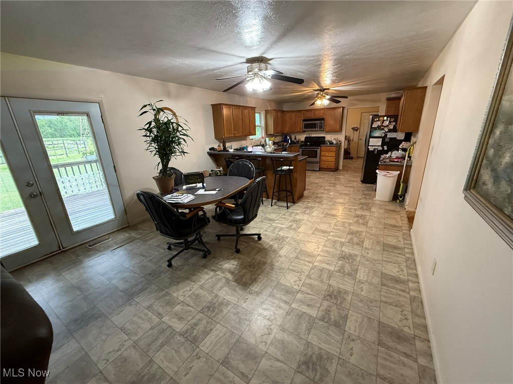 Dining space featuring plenty of natural light, ceiling fan, and a textured ceiling
