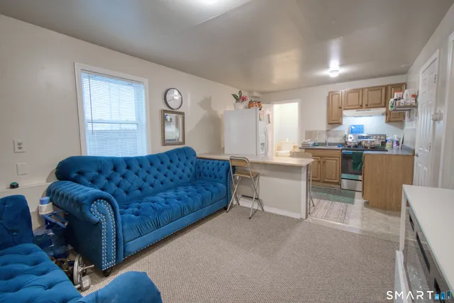 a living room with furniture and kitchen view