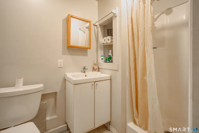 a bathroom with a sink and mirror with toilet