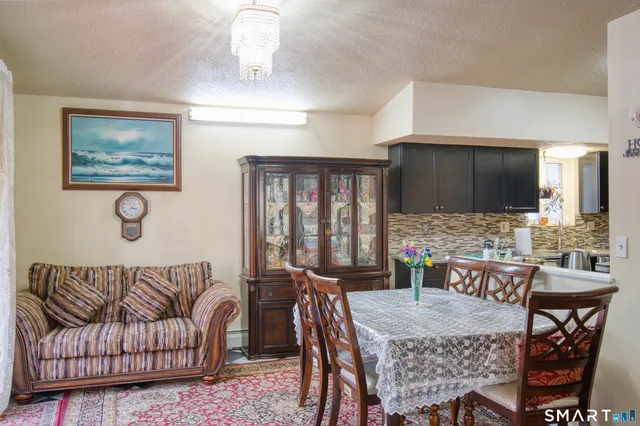 a living room with furniture a flat screen tv and kitchen view