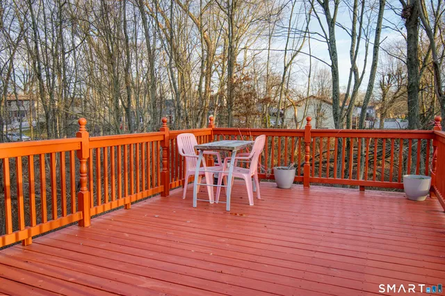 a view of a chairs and table on the wooden roof deck