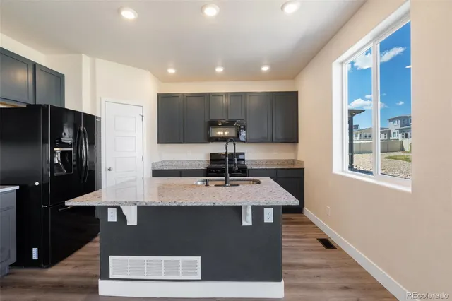 a kitchen with kitchen island stainless steel appliances a sink stove and refrigerator