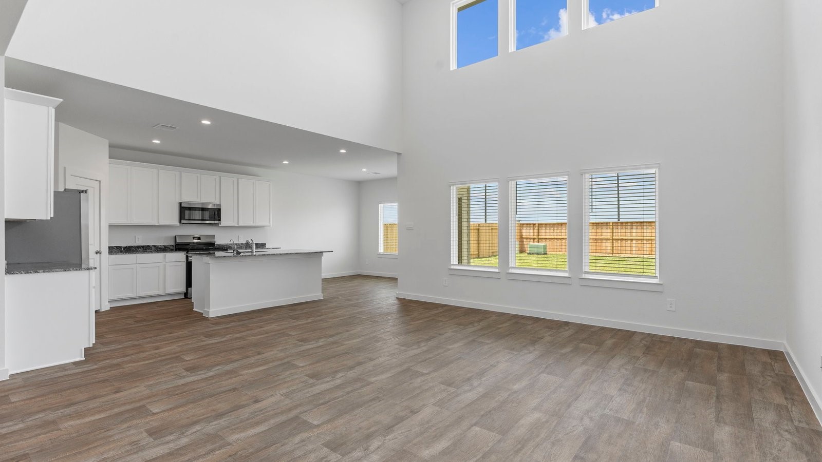 6120 Cherry Mdws Street Rosenberg, TX 77469 - Photo 14 of 39 a view of kitchen with granite countertop refrigerator oven a sink and white cabinets with wooden floor