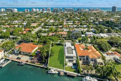an aerial view of a house with a yard and lake view