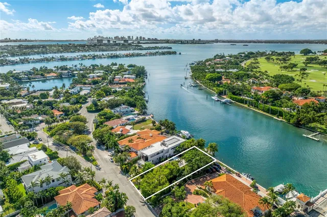 an aerial view of a residential houses with outdoor space and lake view