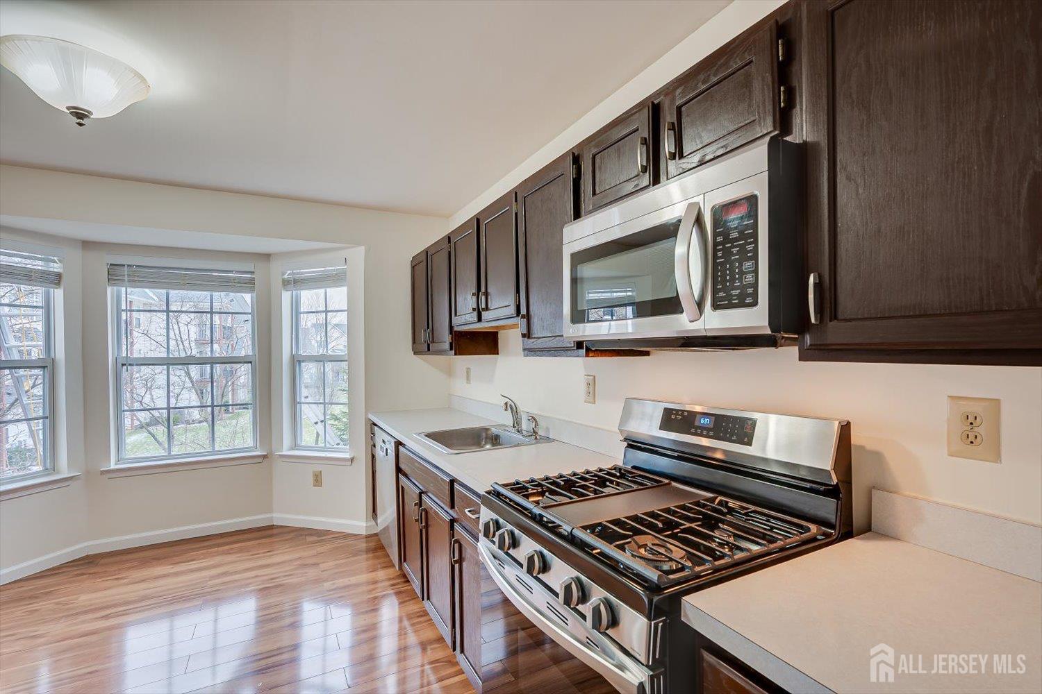 919 Plymouth Road North Brunswick, NJ 08902 - Photo 12 of 33 a kitchen with stainless steel appliances a stove a microwave cabinets and a window