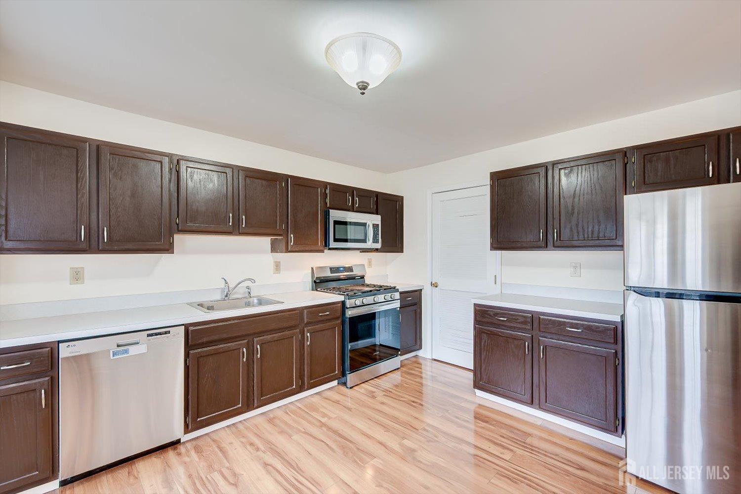 919 Plymouth Road North Brunswick, NJ 08902 - Photo 14 of 33 a kitchen with cabinets stainless steel appliances and wooden floor