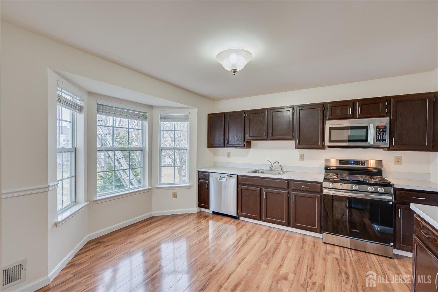 919 Plymouth Road North Brunswick, NJ 08902 - Photo 15 of 33 a kitchen with stainless steel appliances kitchen island granite countertop a stove top oven and sink