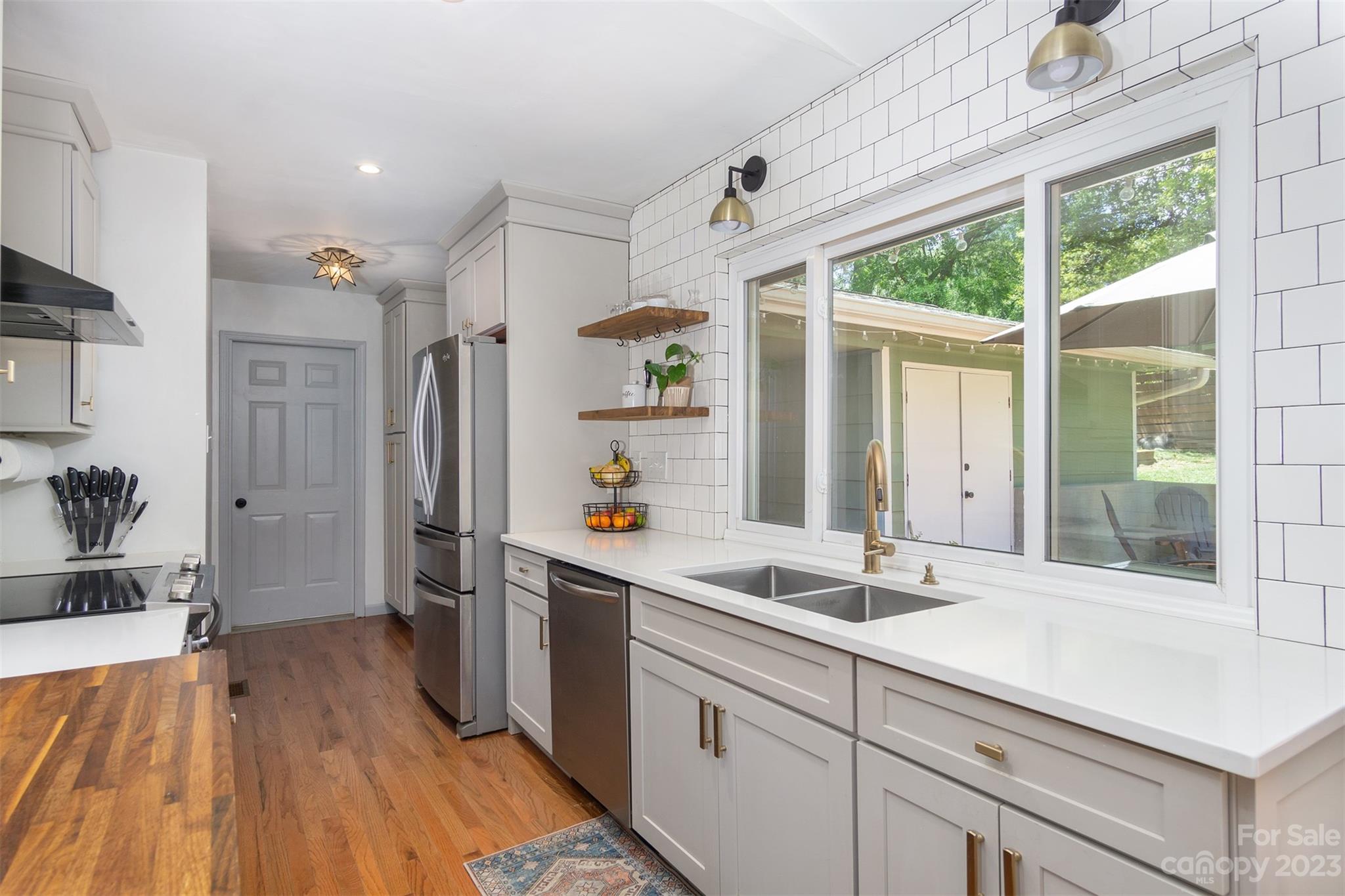 13 Woodfield Road Arden, NC 28704 - Photo 12 of 41 a kitchen with stainless steel appliances a sink window and wooden floor