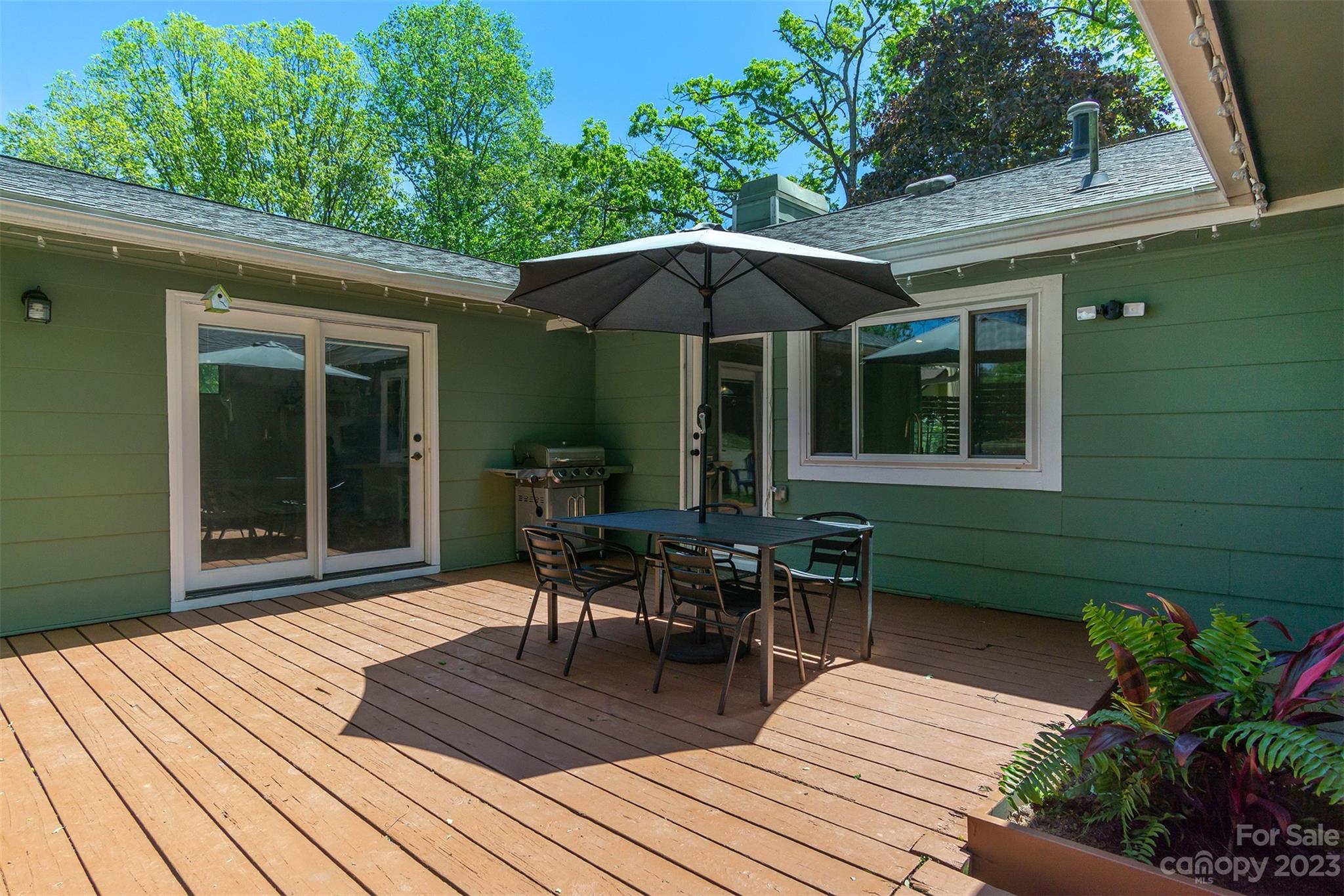 13 Woodfield Road Arden, NC 28704 - Photo 30 of 41 a view of a deck with table and chairs under an umbrella with wooden floor