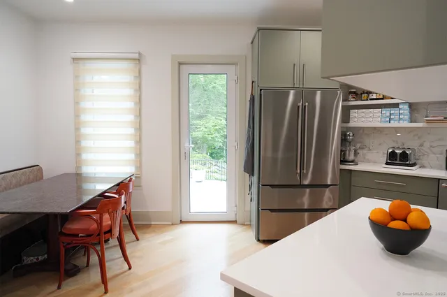 a kitchen with a refrigerator and wooden floor