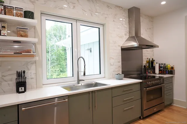 a kitchen with stainless steel appliances a sink stove and cabinets