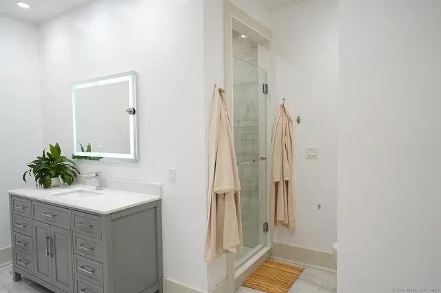 a bathroom with a shower sink and mirror