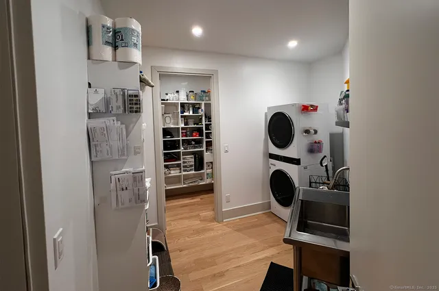 a view of a white house with large windows and a yard