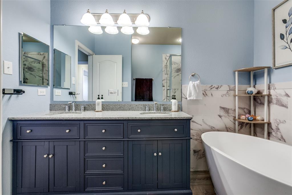 628 Raford Hill Lane Richardson, TX 75081 - Photo 21 of 34 a bath room with a sink a large mirror and a bathtub