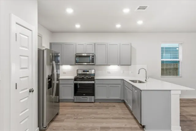 a kitchen with stainless steel appliances granite countertop a refrigerator sink and stove